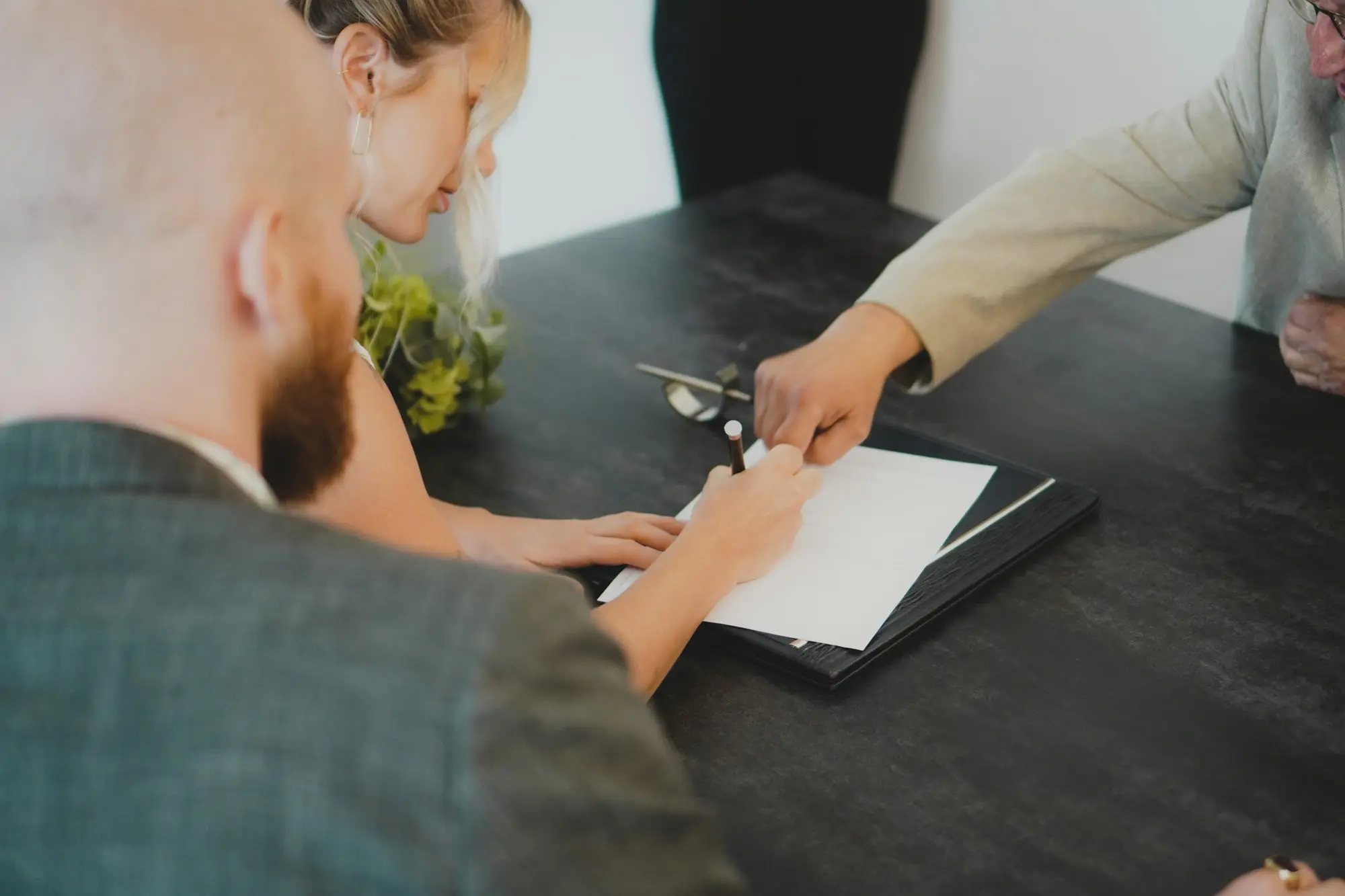 Couple reading and signing a loan document together at a desk
