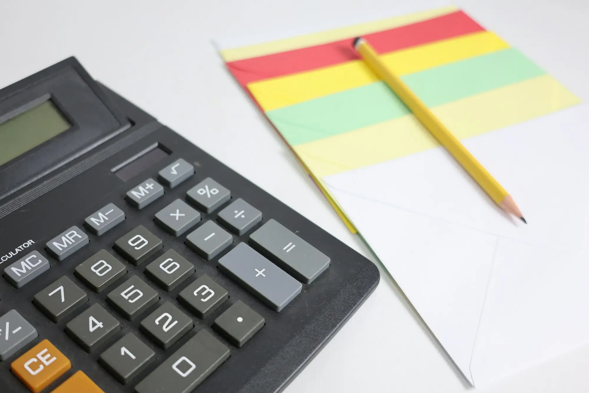Calculator, notepad and pencil laid out to work through an unexpected expense