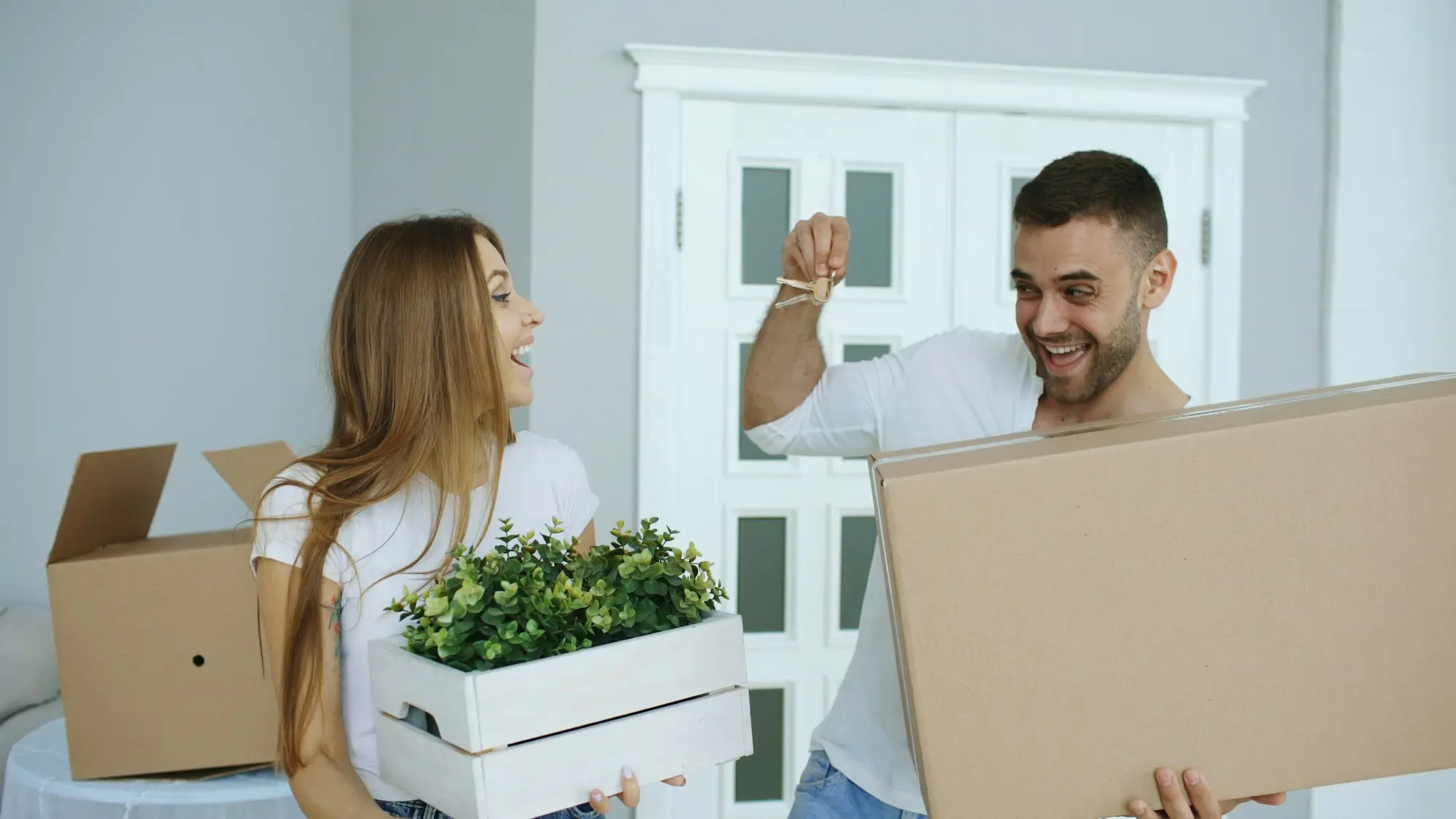 Happy couple unpacking moving boxes in their new home