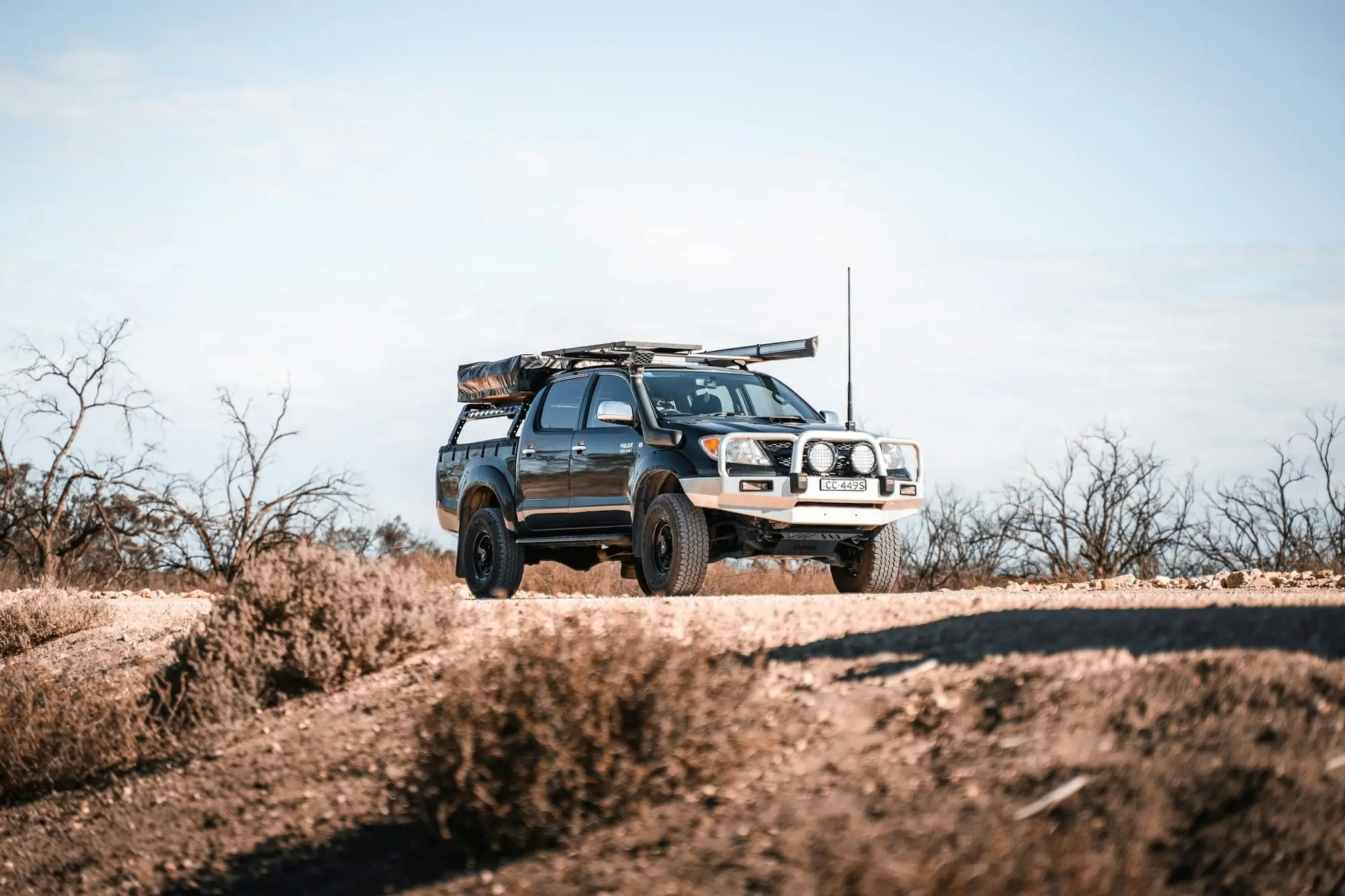 Toyota HiLux 4WD with canopy and bullbar parked in coastal dune scrub